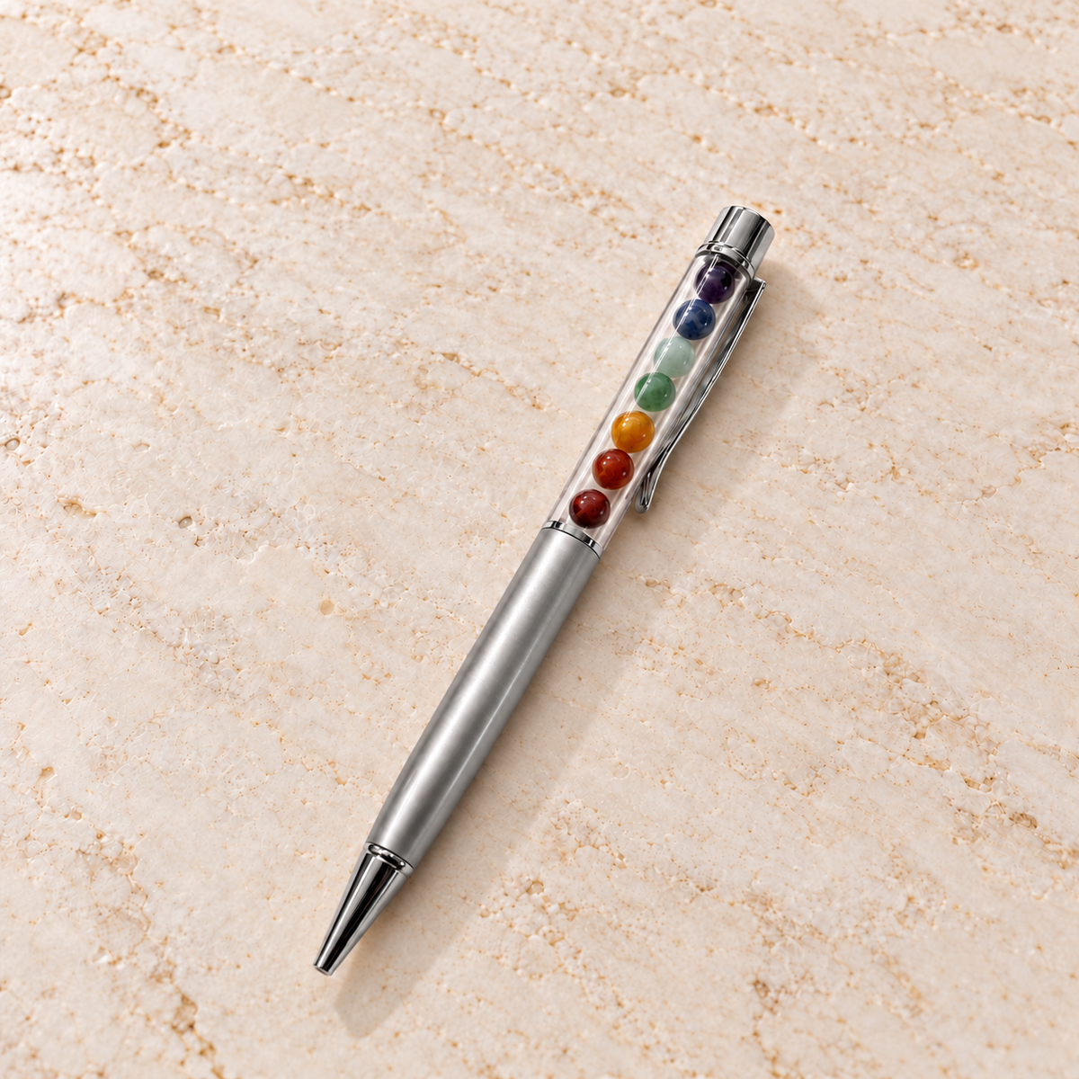 Chakra Edelstein-Kugelschreiber Silber auf heller Marmorfläche